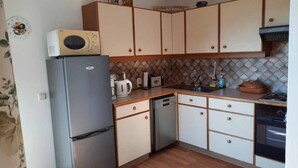 Cocina compacta equipada con refrigerador, microondas, tostadora y lavavajillas.