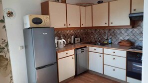 A compact kitchen with a refrigerator, microwave, toaster, and dishwasher. - Doppelzimmer 2 - Haus Gertraud Brand (Gahberg)