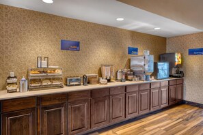 A breakfast bar with a variety of food items and beverages, including a coffee machine and a refrigerator. - Best Western Bandera Suites & Saloon (Bandera)