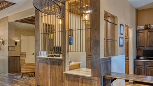 A reception area with a wooden reception desk, a chair, and a counter. - Best Western Bandera Suites & Saloon (Bandera)