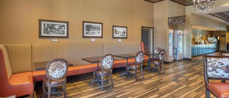A restaurant with a wooden ceiling, a bar area, and a seating area with a bench and chairs.