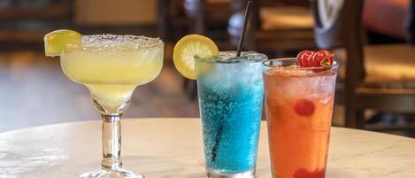 Three cocktails on a marble table.