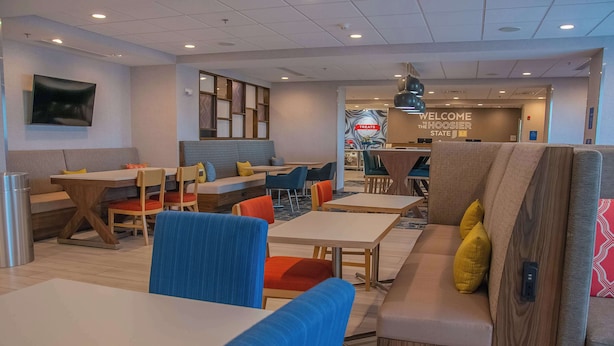 A modern hotel lobby with seating areas, tables, and a reception desk. - Hampton Inn Wabash (Wabash)