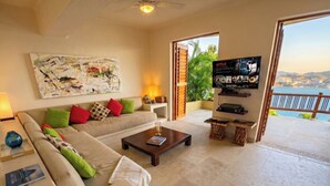 Ein Wohnzimmer mit einer Couch, einem Couchtisch und einem Fernseher, der Netflix anzeigt.