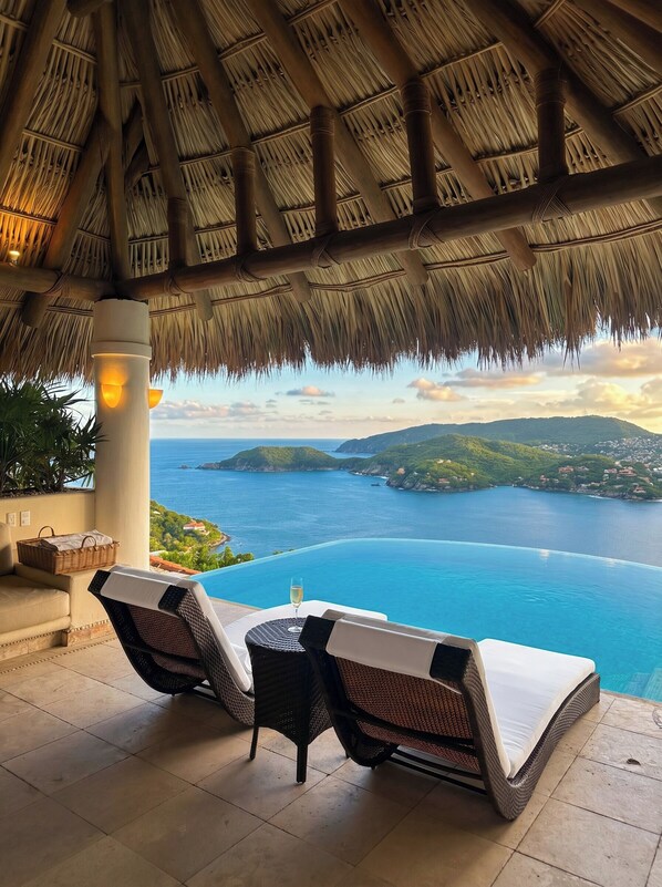 Un espacio de estar techado al aire libre con vista al mar.