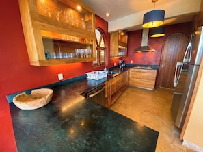 A modern kitchen with a wooden island, built-in wine rack, and stainless steel appliances. - Luxury Home with Breathtaking Views in Zihuatanejo (Zihuatanejo)