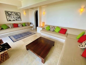 A living room with a sofa, coffee table, and a rug. - Luxury Home with Breathtaking Views in Zihuatanejo (Zihuatanejo)