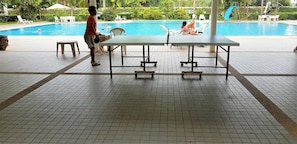 A pool area with tiled flooring, lounge chairs, and a table. - Spacious 3rd Floor Studio at Baan Suan Lalana (Pattaya)