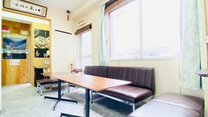 A room with a wooden table, a bench, and a large window with a view.