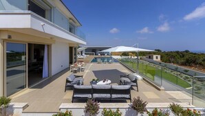 Eine moderne Terrassenanlage im Freien mit Pool, Sitzgelegenheit und Blick auf die Landschaft.