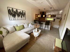 Una sala de estar moderna con un sofá, una mesa de centro y un adorno en la pared.