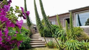 A house with a wooden exterior, a front porch, and a well-maintained garden with various plants and flowers. - "Chez Marinette" à Morgat - Maison & Jardin clos au calme, 6pers, plage à pied - (Crozon Morgat)