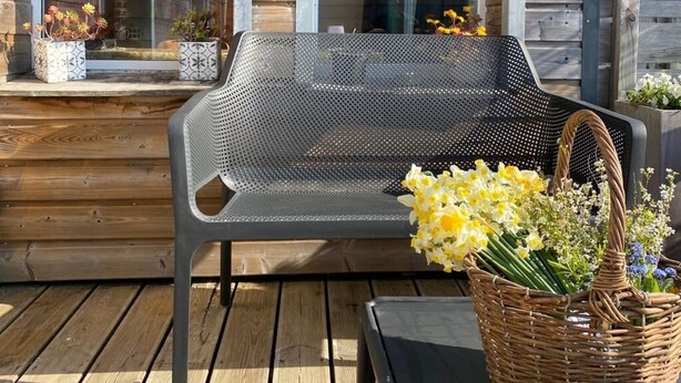 A wooden deck with a metal bench and a wicker basket with flowers. - "Chez Marinette" à Morgat - Maison & Jardin clos au calme, 6pers, plage à pied - (Crozon Morgat)