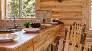A wooden interior with a kitchen counter, a sink, and a dining area with chairs. - Abode at Black Bear #253, hot tub, pool & gym, Deer Valley (Park City)