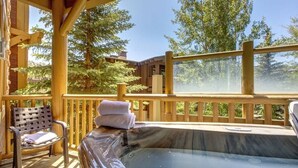 A hot tub on a wooden deck with a bench and towels, surrounded by trees. - Abode at Black Bear #253, hot tub, pool & gym, Deer Valley (Park City)