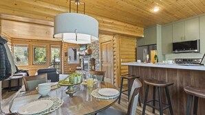 A wooden cabin interior with a dining area, kitchen, and bar. - Abode at Black Bear #353, private hot tub, pool, Deer Valley (Park City)