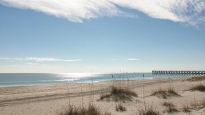 A beach with a pier extending into the water. - Stunning 3 Bedroom Condo Near Crystal Pier (Wrightsville Beach)