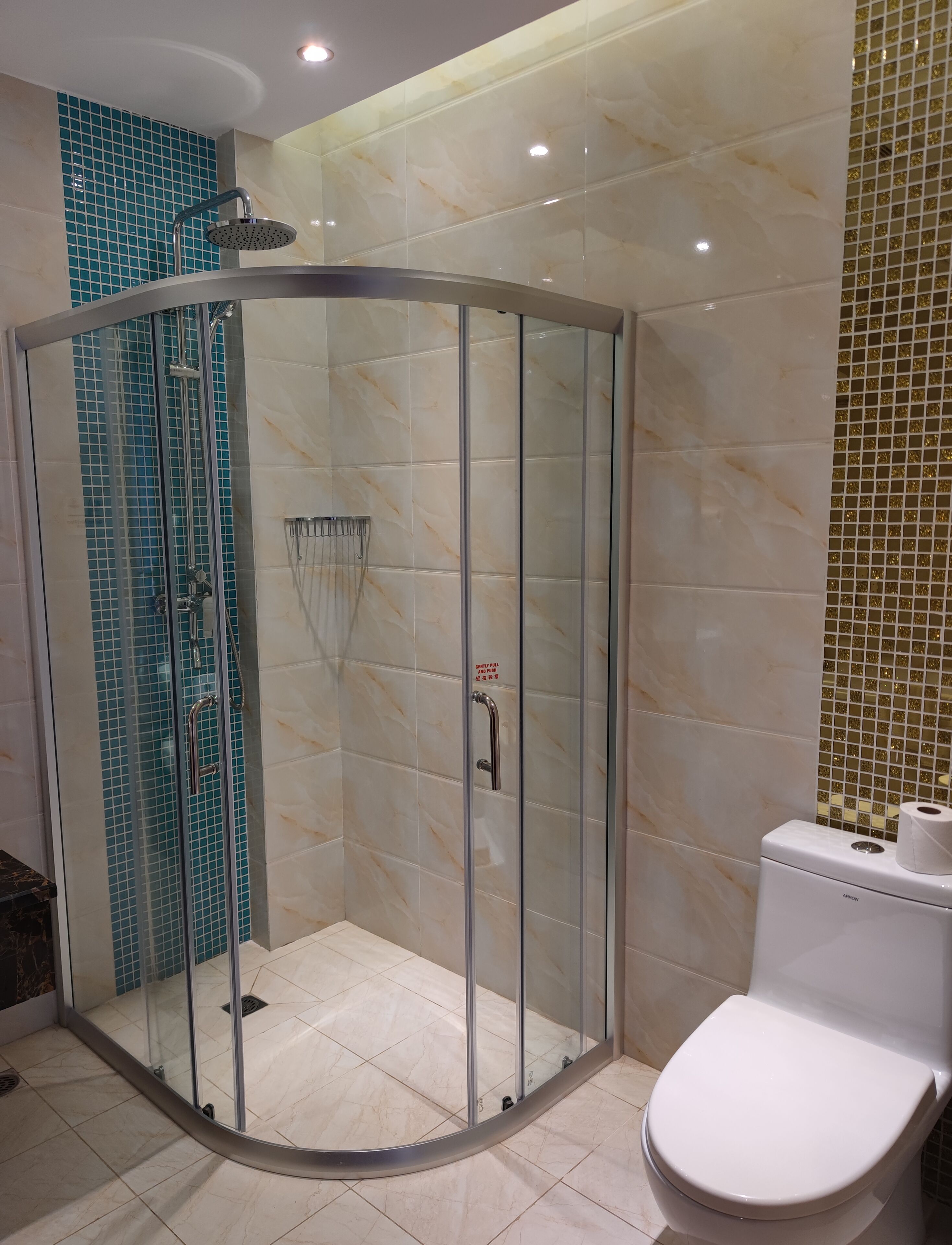 A modern bathroom with a glass-enclosed shower, a toilet, and a sink.