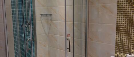 Un baño moderno con ducha envuelta en vidrio, inodoro y lavamanos.