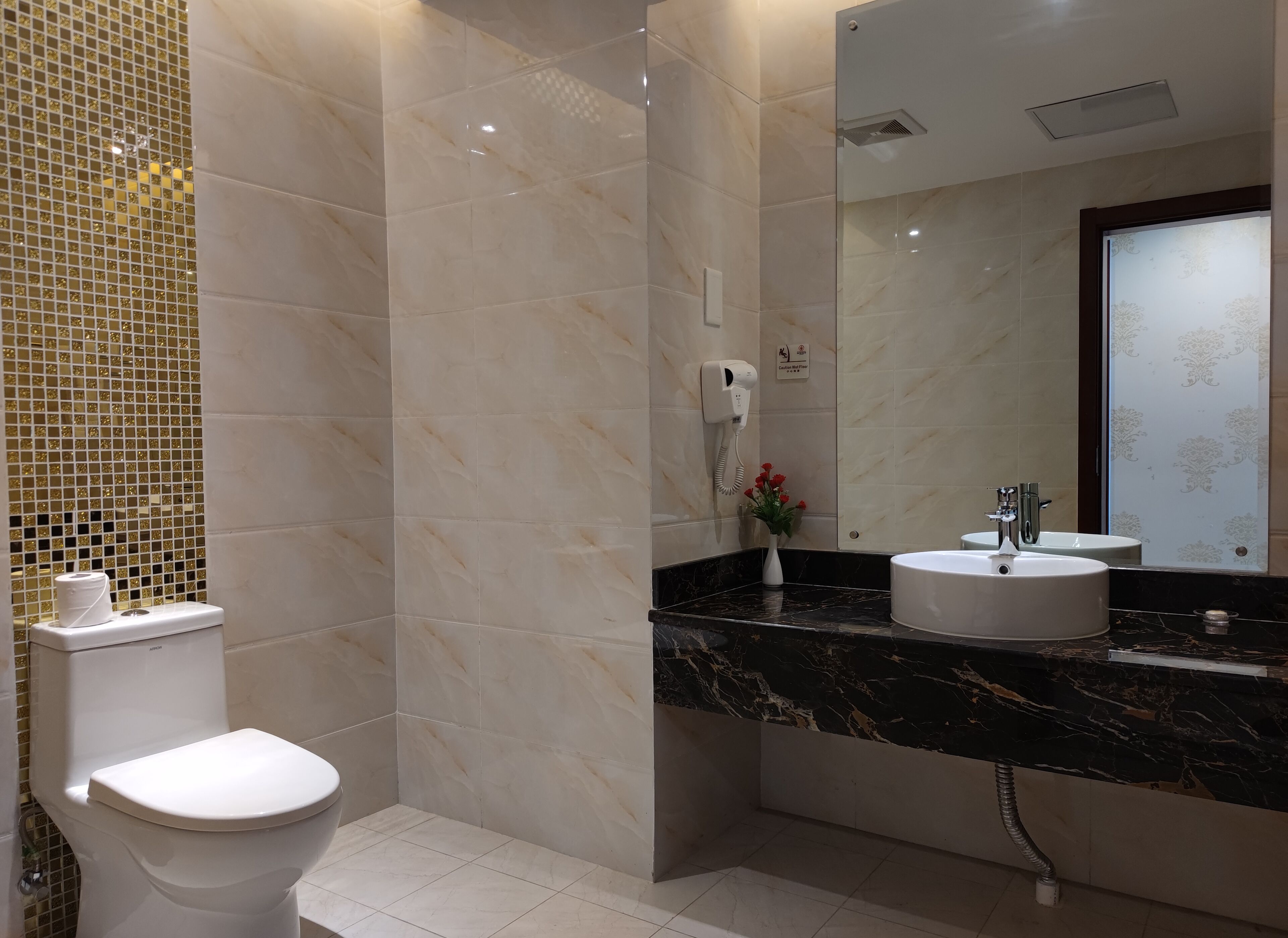 A modern bathroom with a toilet, a sink, and a mirror.