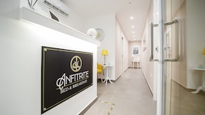 Zona de recepción de un hotel con un cartel que dice 'Anfitrite Bed & Breakfast'.