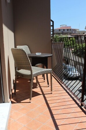 A balcony with wicker furniture, a tiled floor, and a metal railing. - Anfitrite B&B (Tropea)