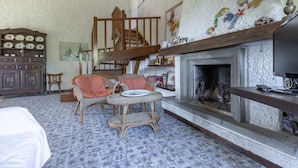 A traditional room with a fireplace, a wooden staircase, wicker furniture, and a patterned floor. - Apartment in Porto Recanati with 4 bedrooms sleeps 8 (Porto Recanati)