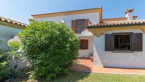 A two-story house with a tiled roof, a small balcony, and a garden area with a large bush. - Apartment in Porto Recanati with 4 bedrooms sleeps 8 (Porto Recanati)