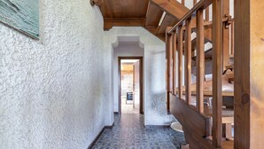 A hallway with patterned tiles, wooden railings, and a view into a room with a tiled floor and a stove. - Apartment in Porto Recanati with 4 bedrooms sleeps 8 (Porto Recanati)