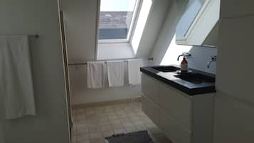 Une salle de bain moderne avec un puits de lumière, un lavabo et un porte-serviettes.