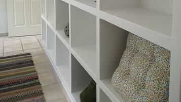 Ein Flur mit einem weißen Schrank, einem gemusterten Teppich und einer Tür.