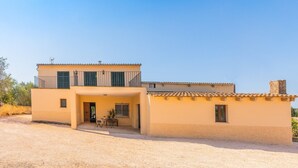 A two-story building with a balcony, a small patio area, and a gravel driveway. - CA SA Lloritana - 6 pax, private pool, wifi free! (Sencelles)
