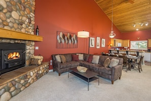 Relax in this inviting living room with a fireplace, sofa, and dining area.