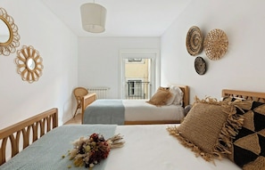A bedroom with a bed, a chair, and a window.