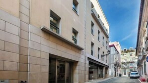 Un bâtiment à la façade moderne, doté de grandes fenêtres et d’une entrée située au niveau du sol.