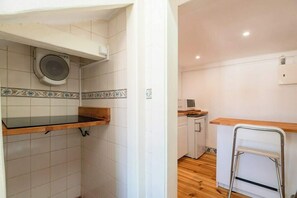 A compact kitchen with a microwave, a small refrigerator, and a wooden countertop. - Bairro Alto Attic Apartment With Balcony (Lisboa)