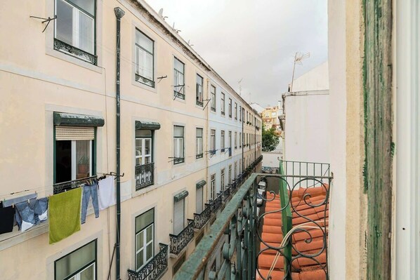 A narrow street with buildings, balconies, and a metal staircase. - Bairro Alto Attic Apartment With Balcony (Lisboa)