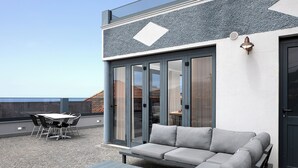 An outdoor seating area with a sofa, table, and chairs. - ANGEL'S SUNSET T2 ESTRITO DA CALHETA (Estreito da Calheta)