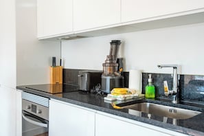 Uma cozinha moderna com forno embutido, cafeteira e pia.