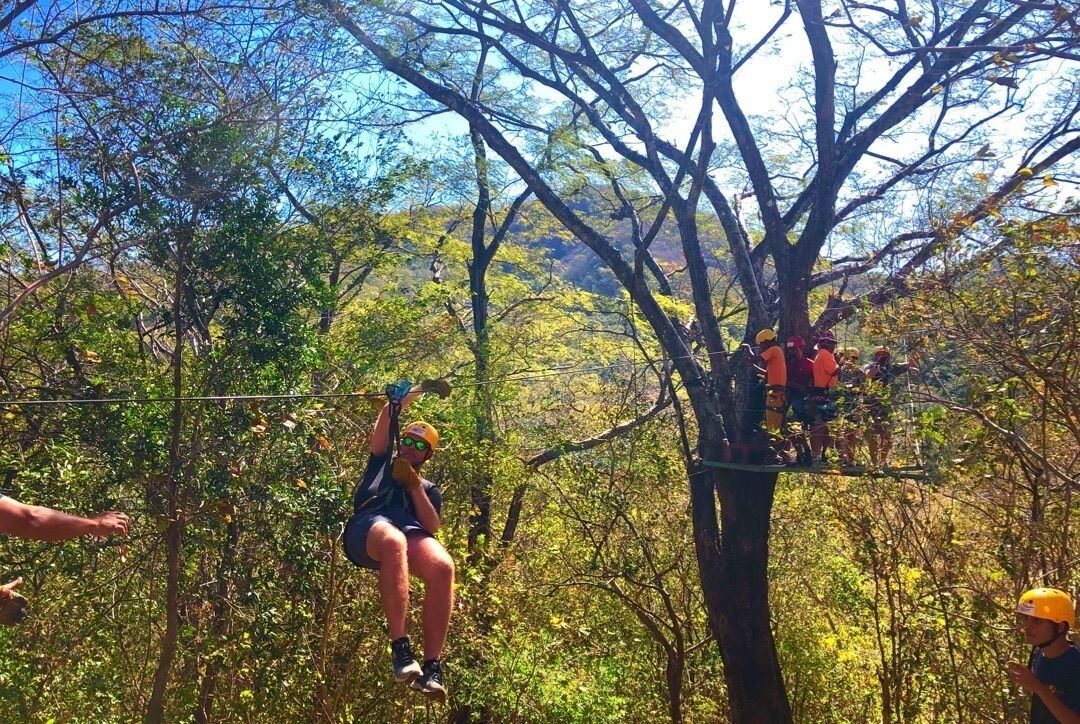 An outdoor adventure activity with participants on a zip line.