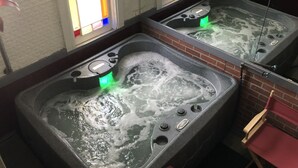 Un área de spa con dos jacuzzis, cada uno con un panel de control y una luz verde visible.