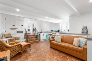 A modern interior with a living area, kitchen, and laundry room.