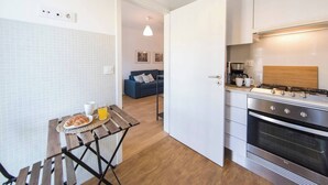 A compact kitchen with a stove, oven, and a dining area with a table set for breakfast.