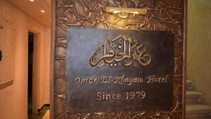 Een hotelschilt met Arabische tekst en de Engelse tekst 'Omar El-Khayam Hotel Since 1979'.