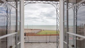 Un balcón con vista a la playa y una barandilla.