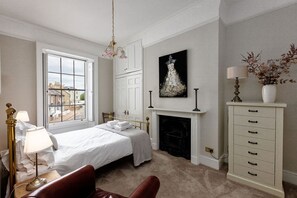 A bedroom with a bed, a fireplace, a window, and a view of the outside. - BEACH VIEW | Coastal Escape | Balcony | Sea Views (Ramsgate)