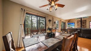 A dining area with a wooden table, chairs, and a ceiling fan. - Exquisite Vacation Home with Hot Tub, EV Charger (Arnold)