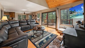 A spacious living room with a leather sectional sofa, a round coffee table, and a fireplace. - Exquisite Vacation Home with Hot Tub, EV Charger (Arnold)