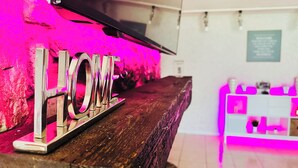 Una recepción con un cartel que dice 'HOME' y una vitrina iluminada en rosa.