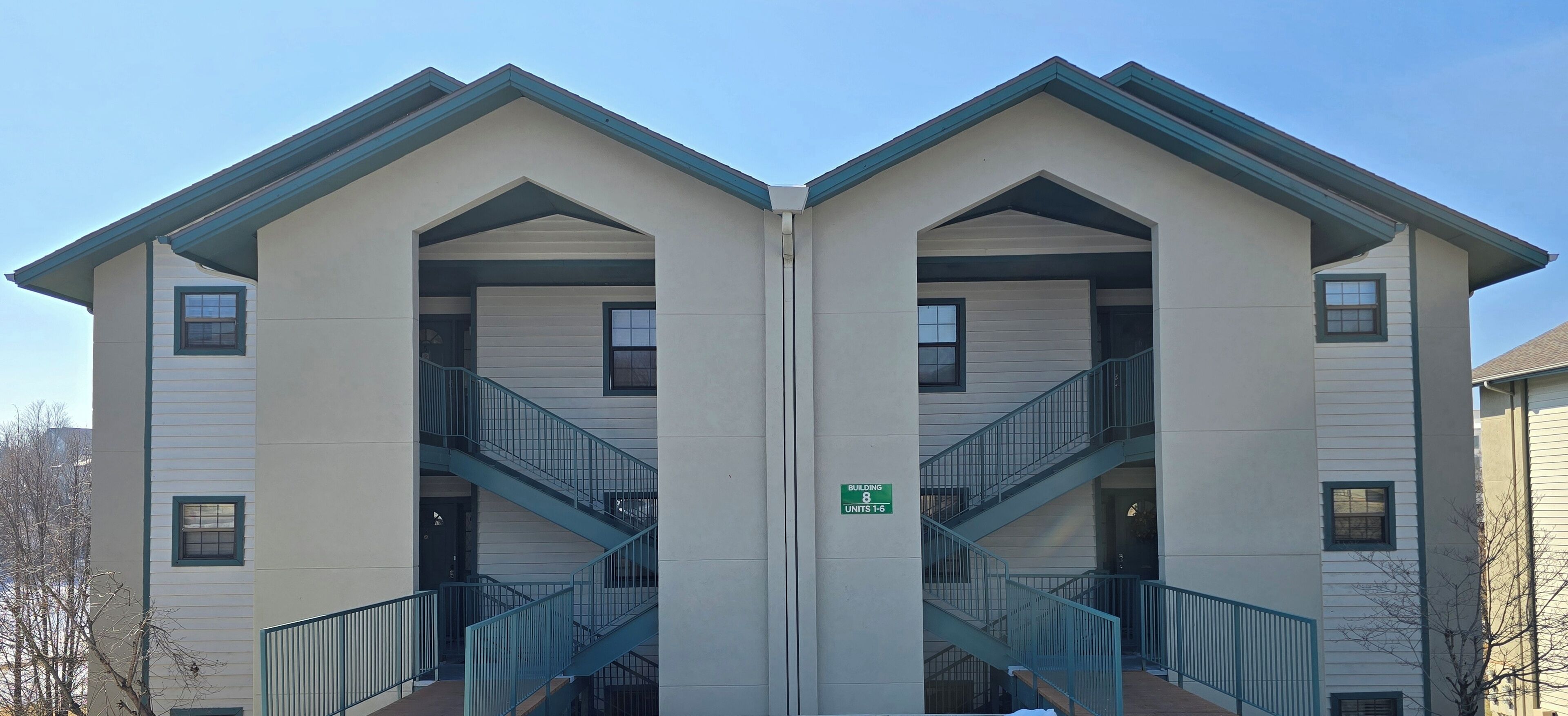 A symmetrical building with two staircases, a sign indicating it is Building 8, and units 1-6.